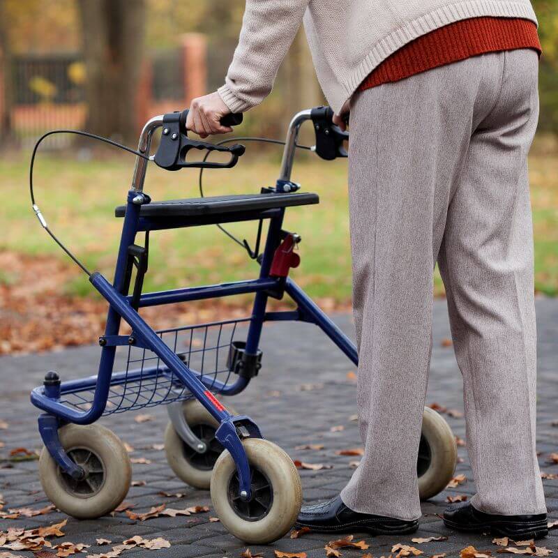 Senior using rollator walk aid with 360 wheels and ergonomic handles